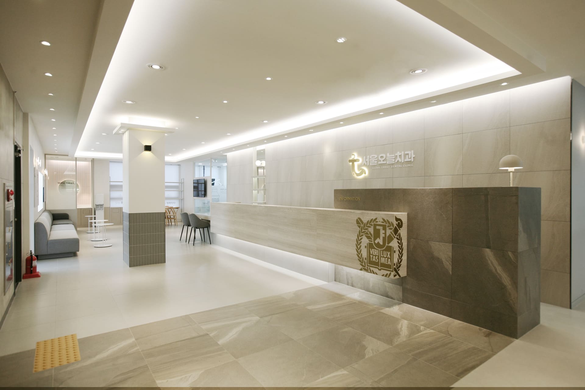 Bright, spacious lobby and waiting area of Seoul Today Dental Clinic with warm stone surfaces and soft lighting